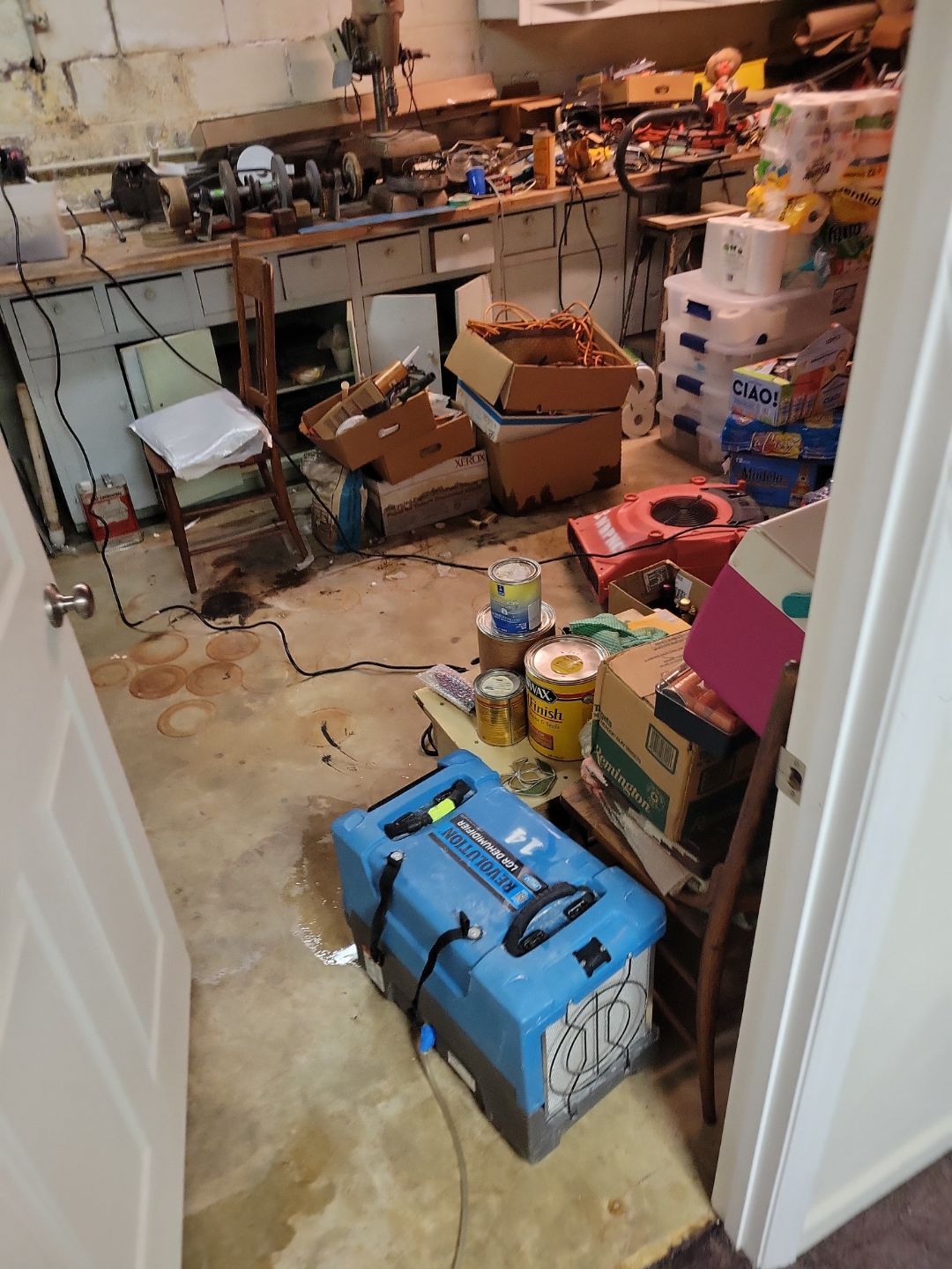 When Is Professional Water Damage Restoration Needed In Fayetteville? 8 Dehumidifier Running In A Cluttered Garage After Water Damage To Dry The Concrete Floor And Reduce Mold Risk In North Carolina