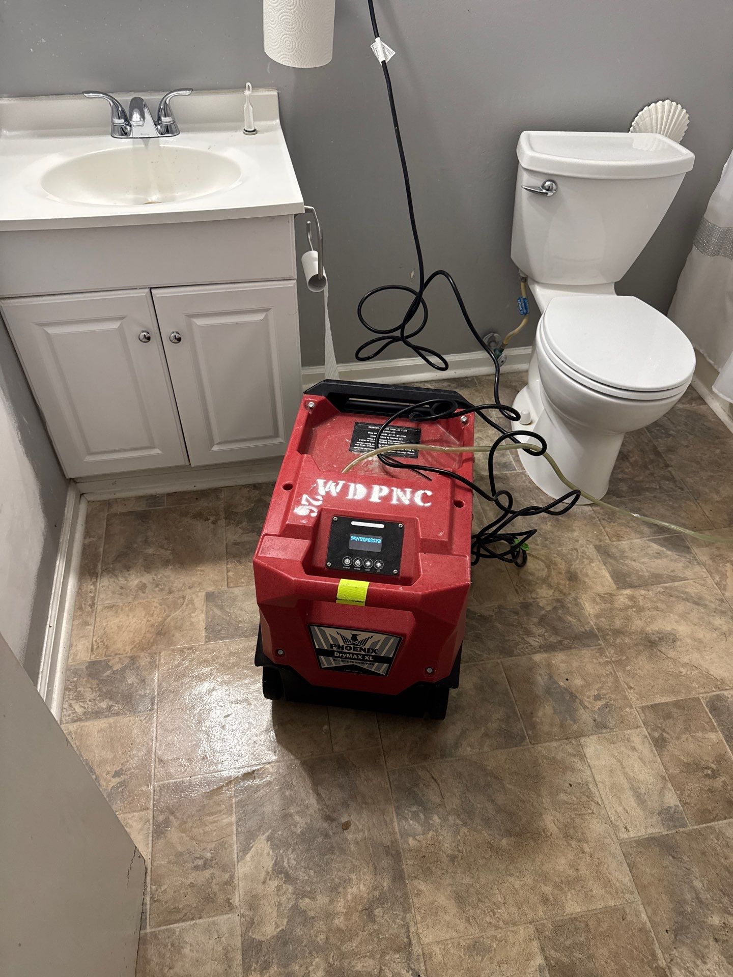 What Is The Difference Between Water Mitigation And Restoration? 7 Water Mitigation Equipment, A Dehumidifier Drying A Bathroom After Water Damage